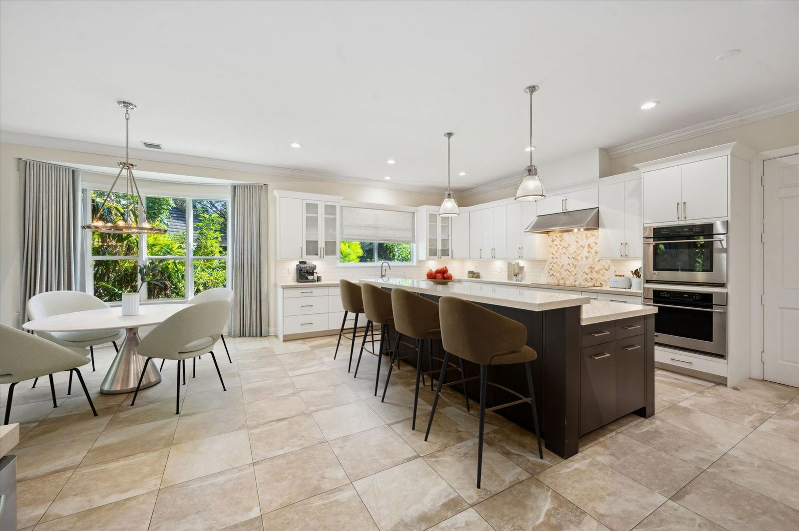 Chef's kitchen with white cabinetry, quartz island, and garden views